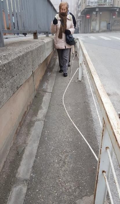 Les barres trencades de la barana estan al mig de la vorera i compliquen el pas dels vianants