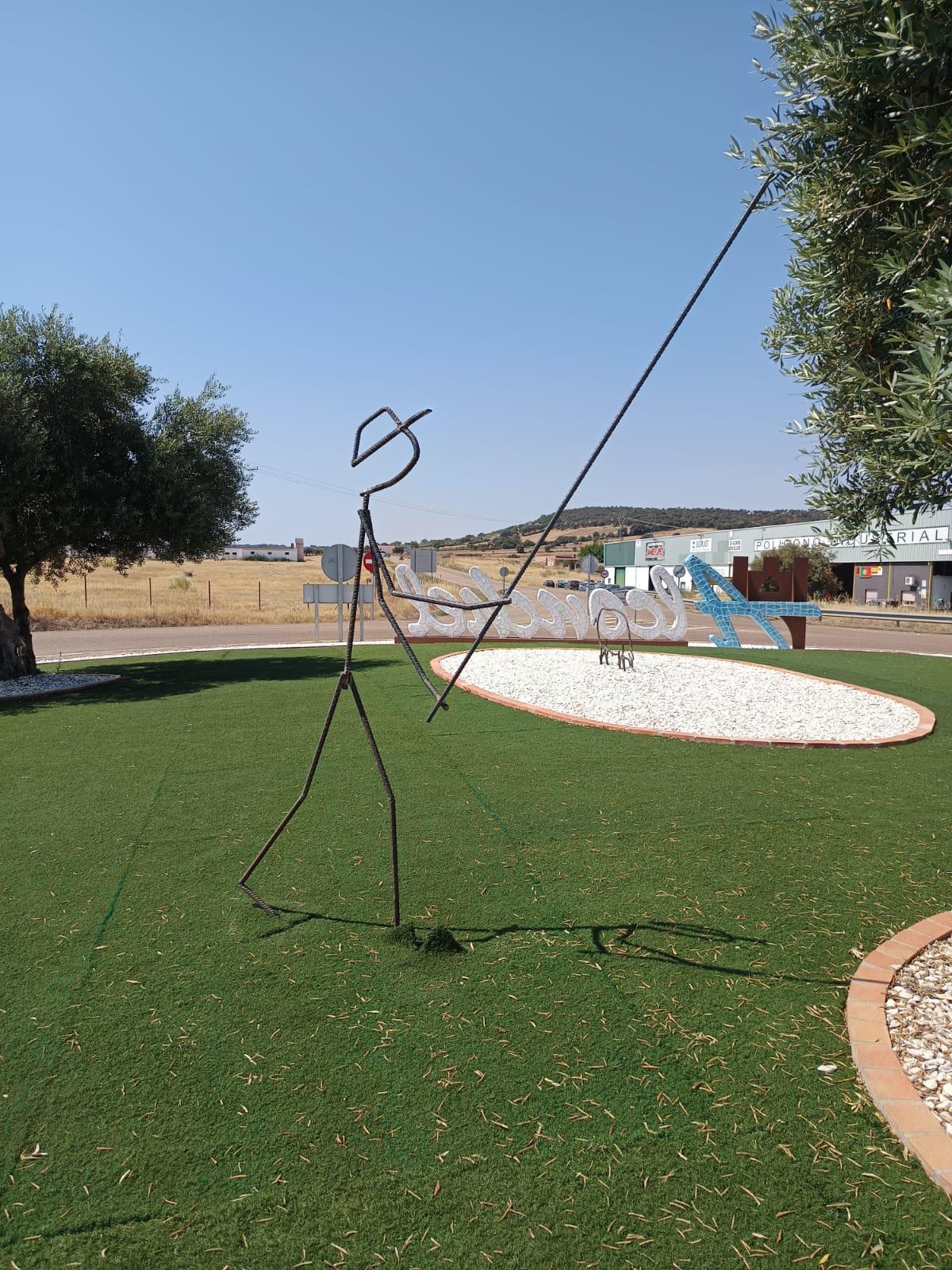 Escultura de un hombre vareando un olivo real