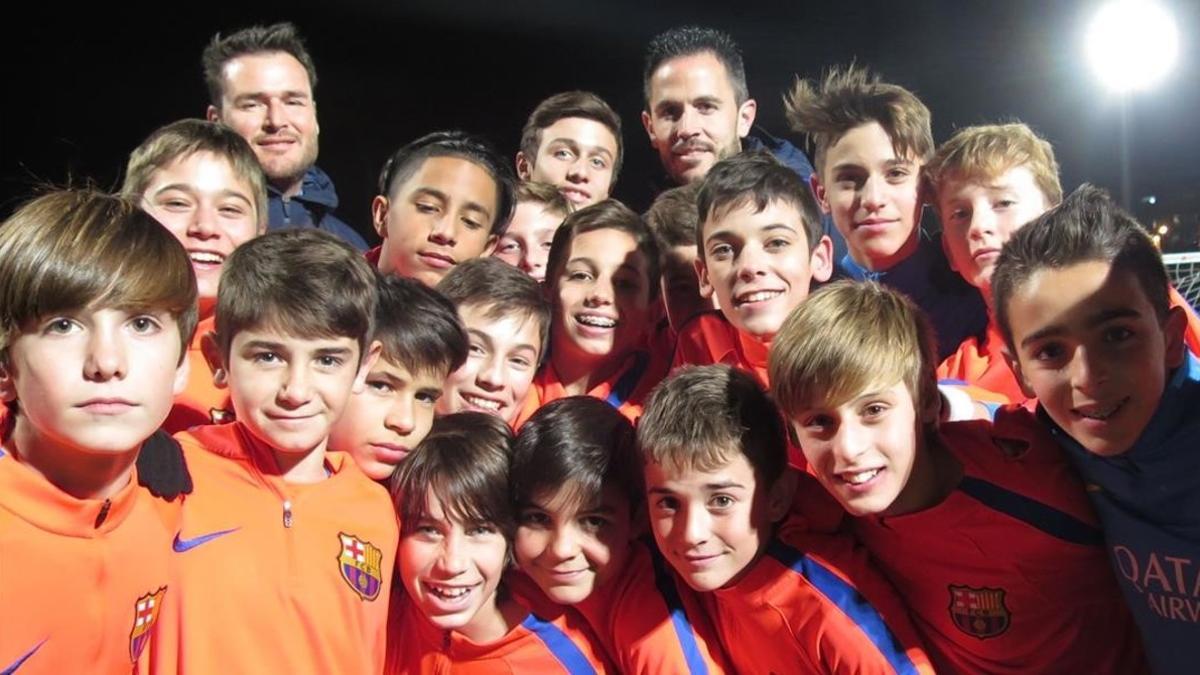 Los integrantes del infantil B del Barça, junto a sus entrenadores, Óscar Hernández y Sergi Milá, en la Ciutat Esportiva Joan Gamper, este jueves.