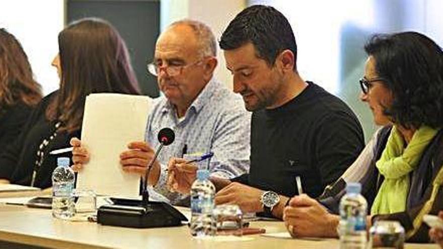 Joan Torres recoge unos documentos en un pleno, y a su lado, el candidato del PP, Marcos Serra.