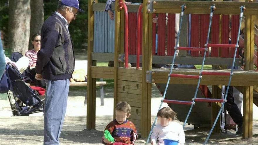 Un abuelo con sus dos nietos en un parque.