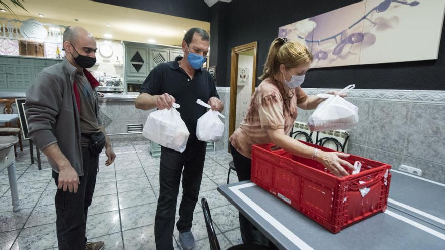 Treballadors d&#039;un restaurant preparant plats per fer un servei a domicili