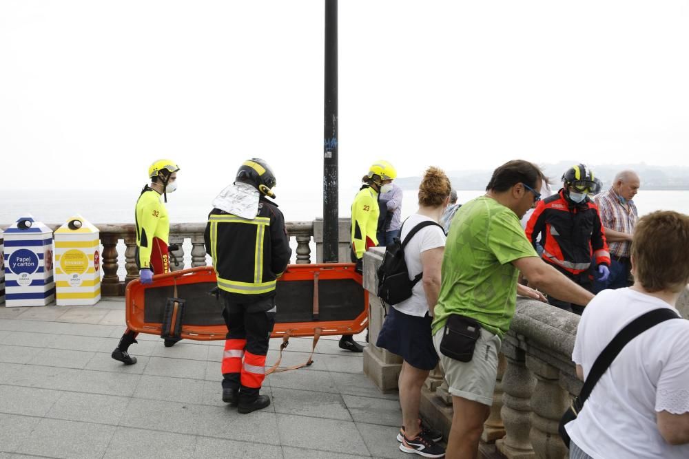 Rescatan a una mujer que se precipitó a las rocas de la playa de San Lorenzo en Gijón.