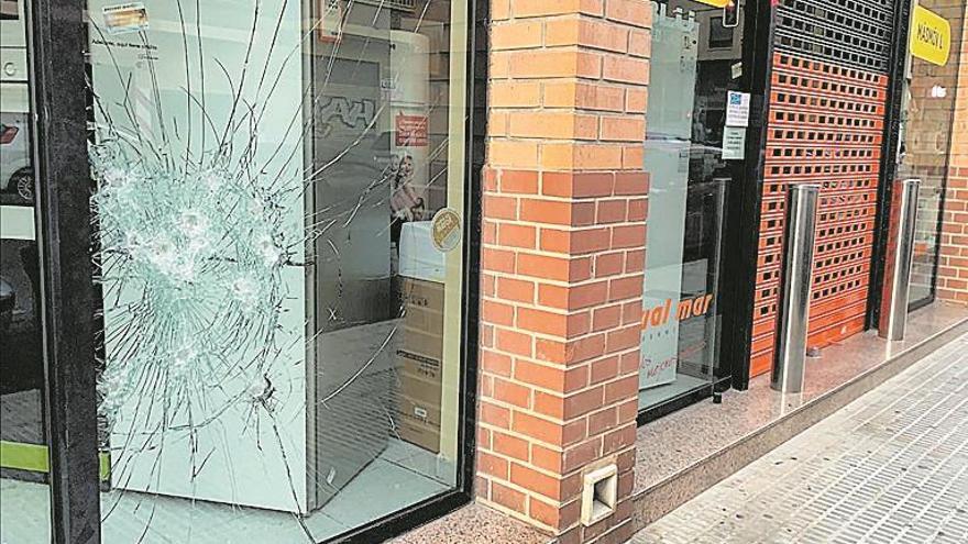 Tres comercios cercanos amanecen con los cristales rotos en Castelló