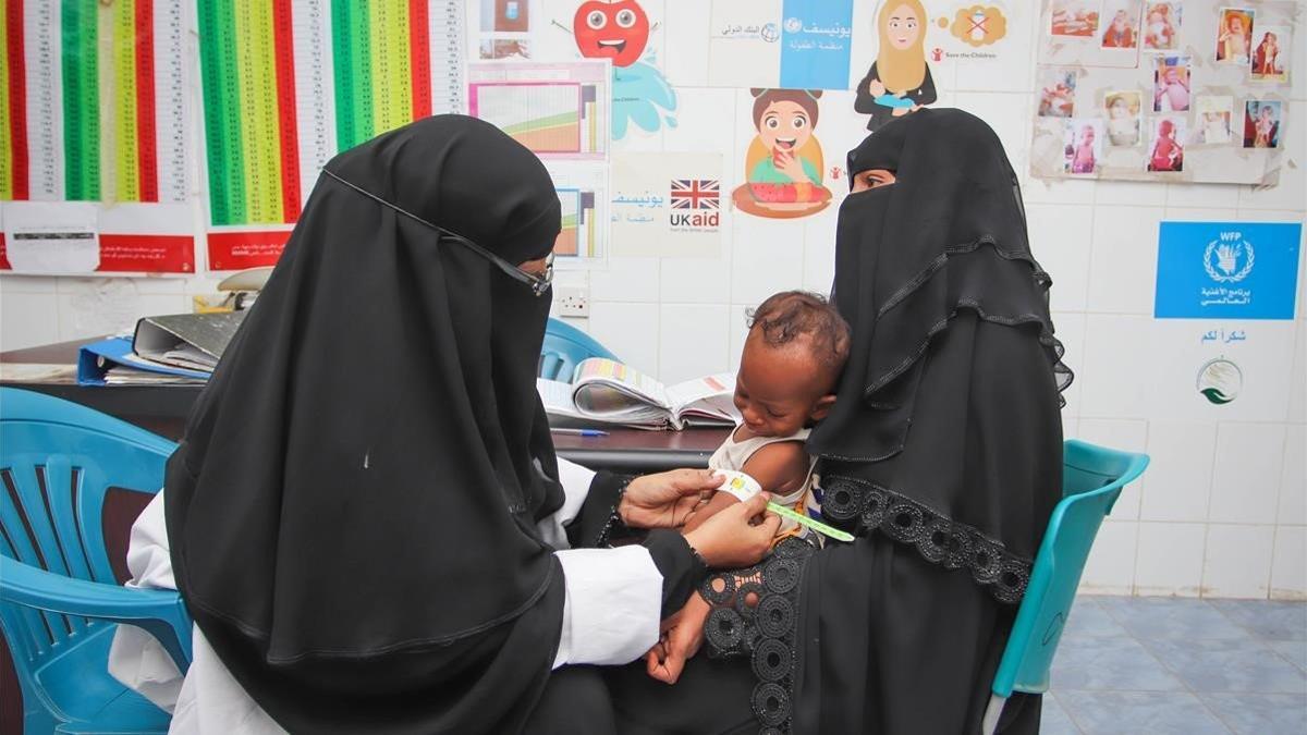 Una matrona ausculta Rafiq, un niño de 7 meses  que sufre de malnutrición, en Adén (Yemen).