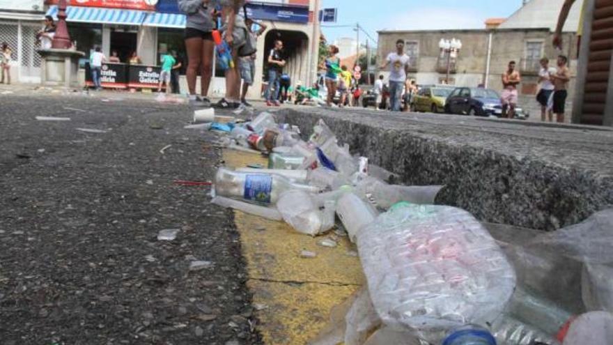 Restos del &quot;botellón&quot; la noche previa a la Festa da Auga de este año, con una barra al fondo.  // J. L. Oubiña