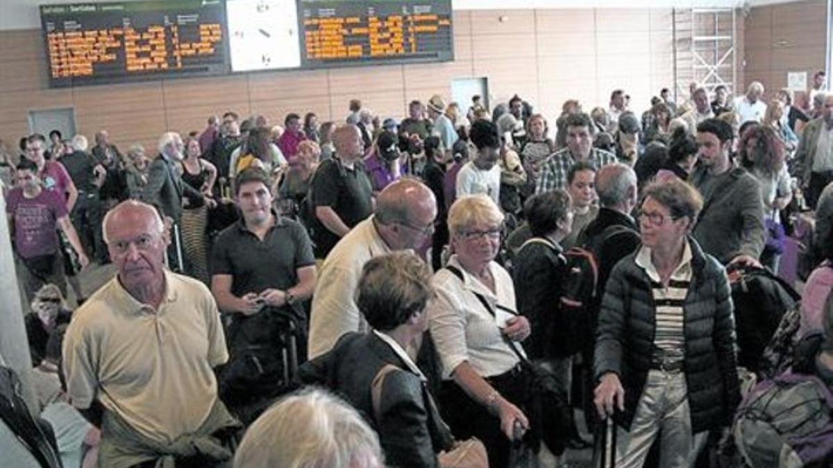 Aglomeración de pasajeros en la estación del AVE de Girona a la espera de un autocar alternativo, ayer.