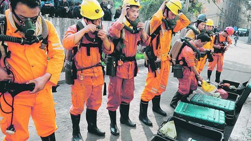 Miembros del equipo de rescate, preparándose para entrar en la mina china donde ya han fallecido 26 trabajadores.