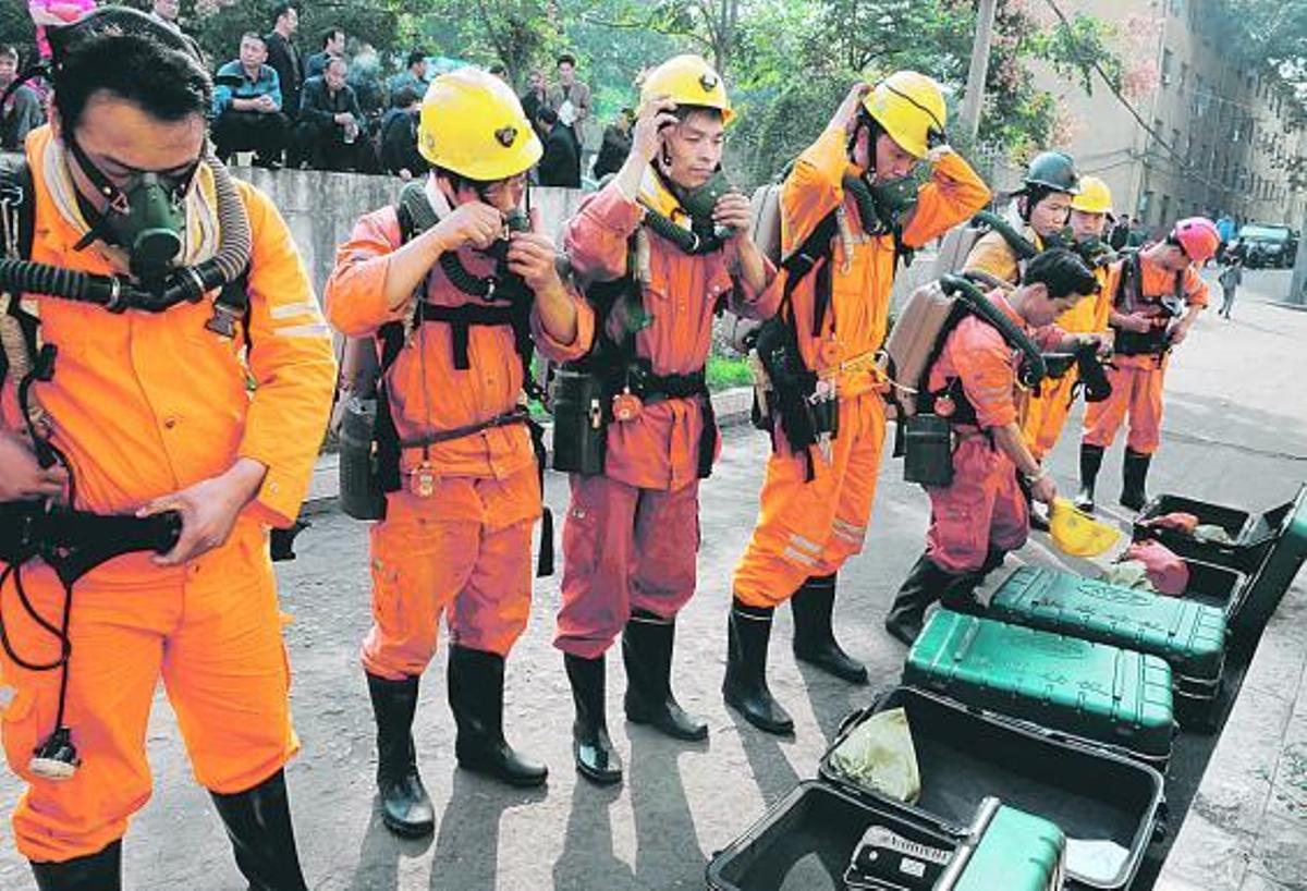 Miembros del equipo de rescate, preparándose para entrar en la mina china donde ya han fallecido 26 trabajadores.