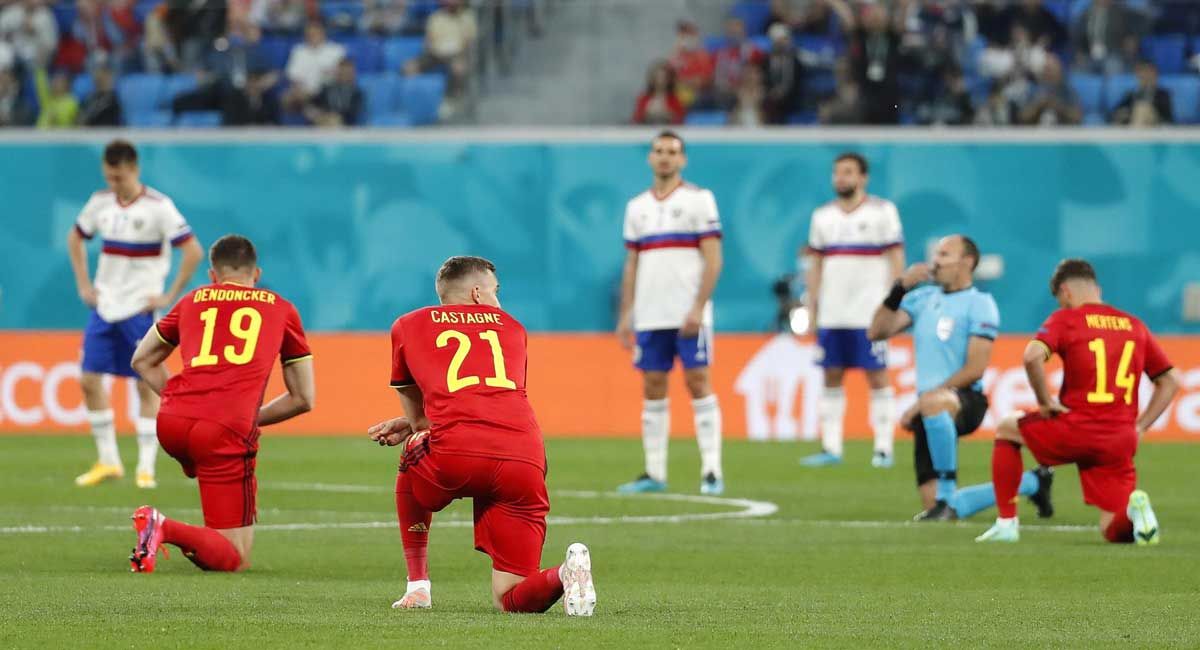 Los jugadores de Bélgica, arrodillados ante la mirada de los futbolistas rusos.