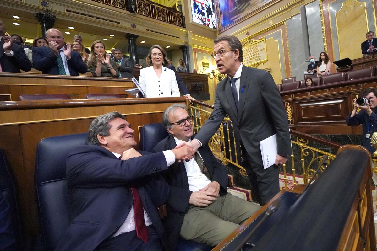 Alberto Núñez Feijóo, este martes en el Congreso, saluda al ministro de Seguridad Social, José Luis Escrivá, sentado junto al de Universidades, Joan Subirats.