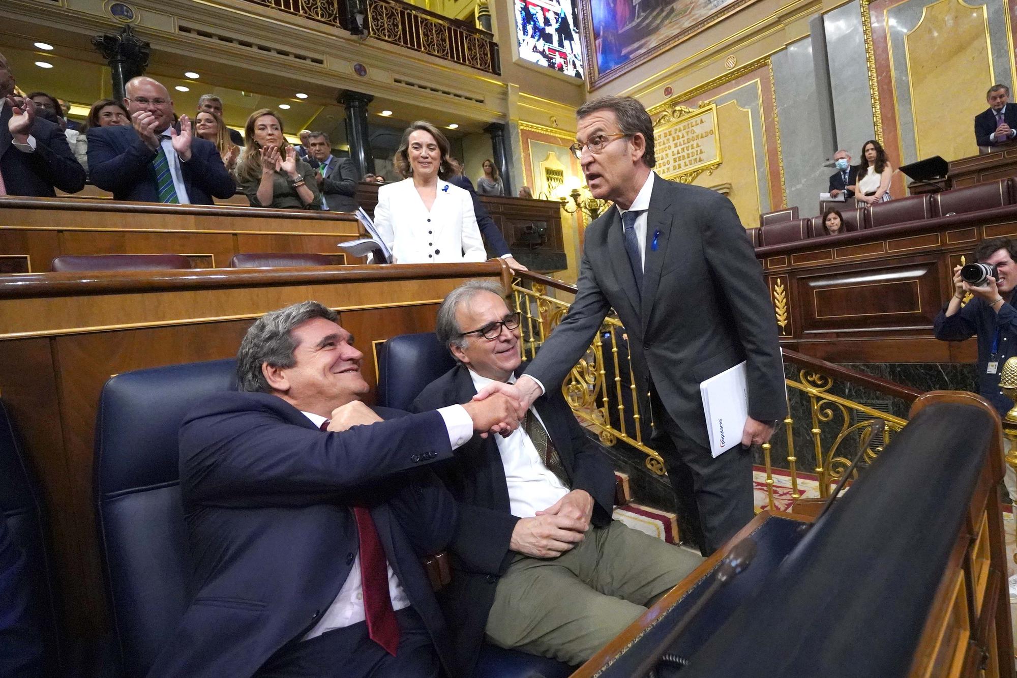 Alberto Núñez Feijóo, este martes en el Congreso, saluda al ministro José Luis Escrivá.