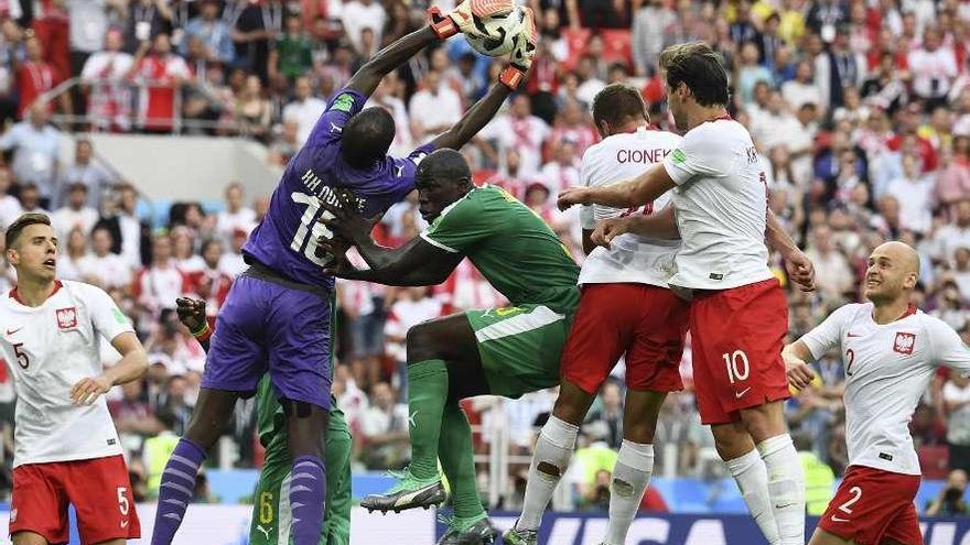 Ndiaye, portero de Senegal, atrapa el balón en una jugada de ataque de Polonia.