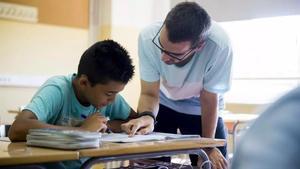 Un estudiante recibe la ayuda de un profesor de apoyo