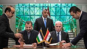 El representante de Fatá, Azam al Ahmad (derecha) y el de Hamás, Saleh al Arouri, firman el acuerdo en El Cairo.