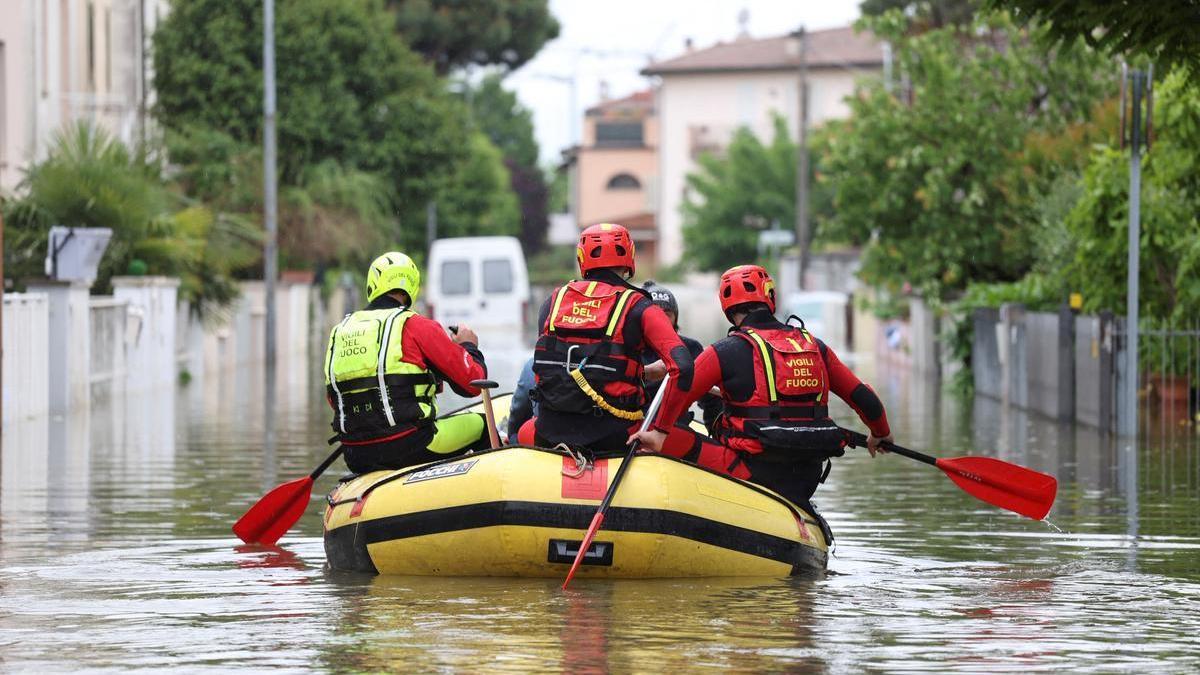 Bomberos llevan agua y comida a personas atrapadas en sus casas por las inundaciones en la region italiana de Emilia Romaña, este viernes.