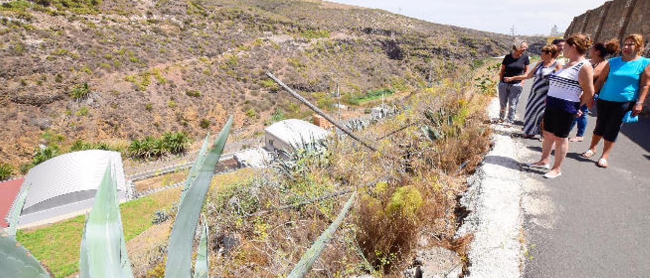 Un grupo de vecinos de Las Majadillas señalan la depuradora, en el fondo del barranco de Tamaraceite.