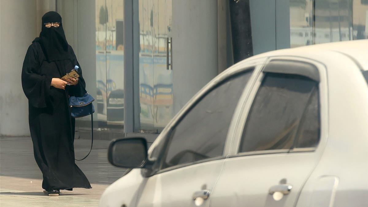 Una mujer saudí camina junto a un coche en una calle de Riad, la capital de Arabia Saudí, el 27 de septiembre.