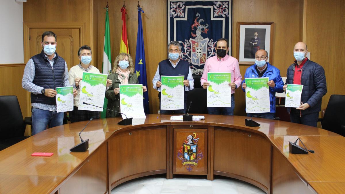 Participantes en la presentación del campeonato de ornitología muestran el cartel.