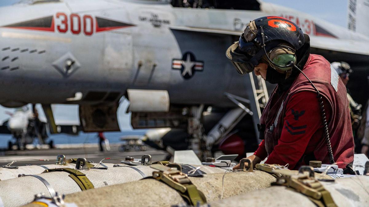 Artilleros de la Armada de los Estados Unidos preparan bombas para un caza.
