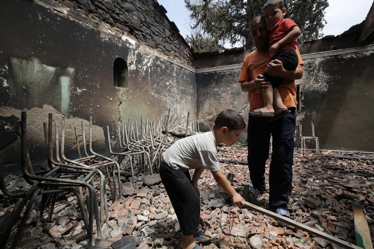 Oeud Das (Algeria), 25/07/2023.- An Algerian man with his children inspects his burned house in the village of de Oeud Das in Bejaia east of Algiers, Algeria, 25 July 2023. The Algerian Ministry of the Interior announced at least 34 people died, including 24 civilians and 10 members of the National Army and 26 people are injured in multiple forest fires across the country. (Argel) EFE/EPA/STR