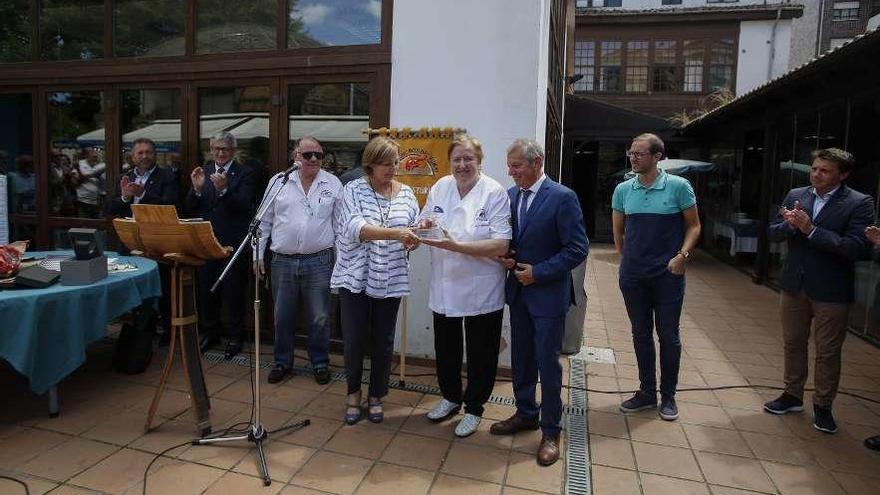 Lola Hernández y Justo García, propietarios de la sidrería Yumay, reciben el premio &quot;Jamón de Plata&quot; de manos de Mariví Monteserín, ante la presencia de su hijo David García Hernández, a la derecha.