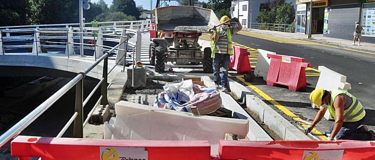 Ayer se apuraban las aceras al lado del puente.