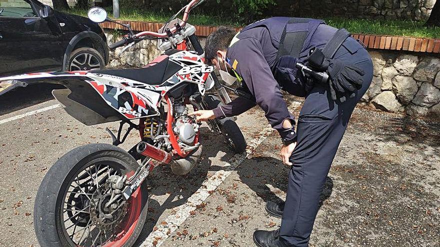 Agent de la Policia Local inspeccionant una motocicleta