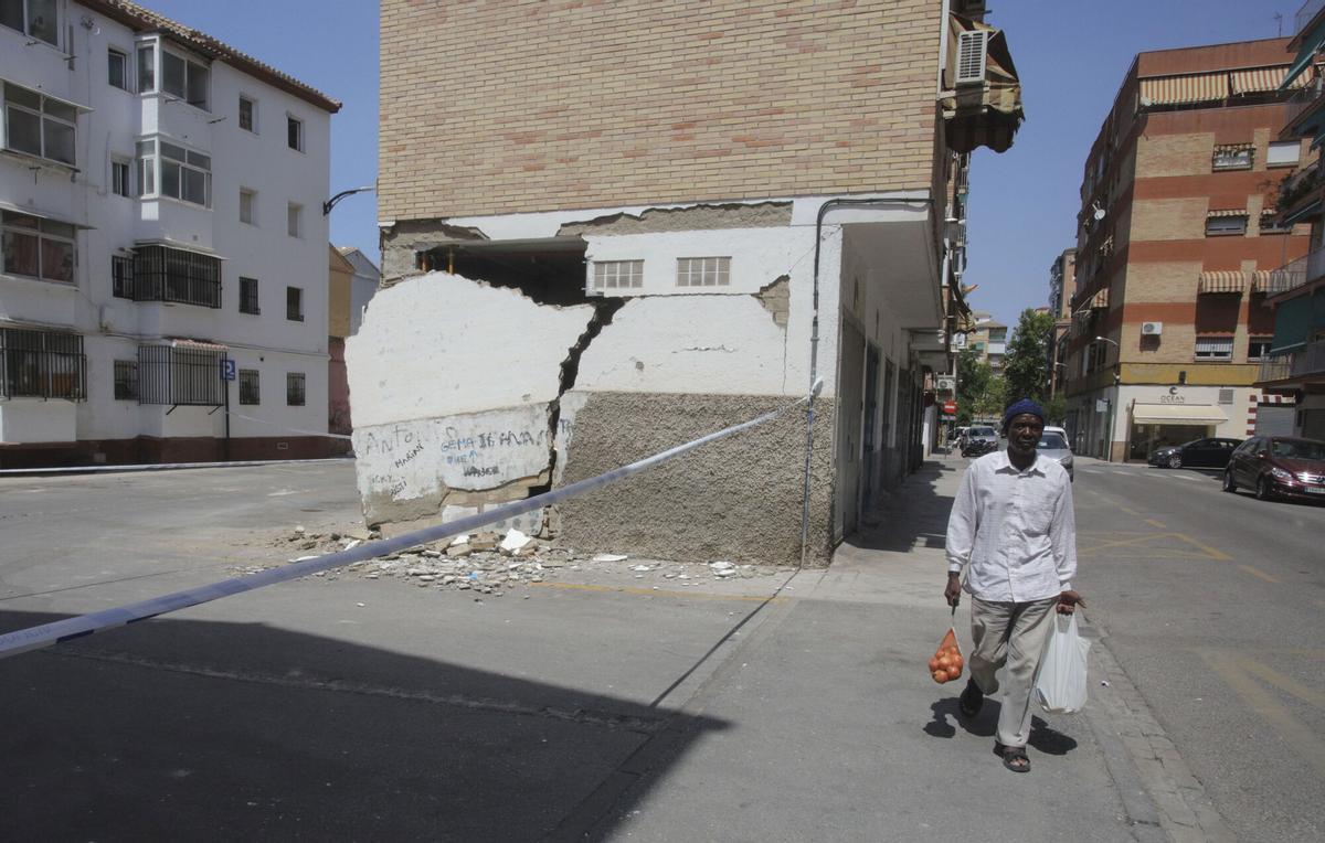 GRANADA 20/08/2026.- Un hombre pasa este jueves junto a una vivienda con desperfectos causados por los terremotos de los días anteriores en Granada. EFE/Pepe Torres