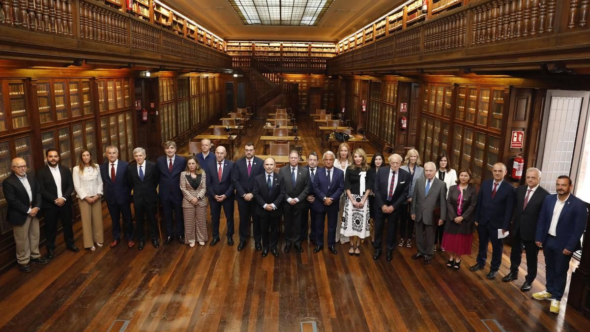 Por la izquierda, en la biblioteca del edificio histórico de la Universidad de Oviedo, Jorge Luis Marquínez, Miguel Ángel Bollo, Ángela Pumariega, Carlos Siñeriz, Javier Barón, Alfonso Palacio, María Calvo, Gustavo Bueno Sánchez, Juan Cofiño, Adrián Barbón, Ignacio Villaverde, Alfredo Canteli, Fernando Martínez, Jesús Chamorro, Loreto Ordóñez, Irene Caro, María Fernández Pérez, Luis Rodríguez Ovejero, Cristina Garmendia, Francisco Rodríguez, Alicia García Cabrera, Vanda Martins, Ignacio Ramos Altamira, Guillermo Ulacia y Manuel Ángel Álvarez.