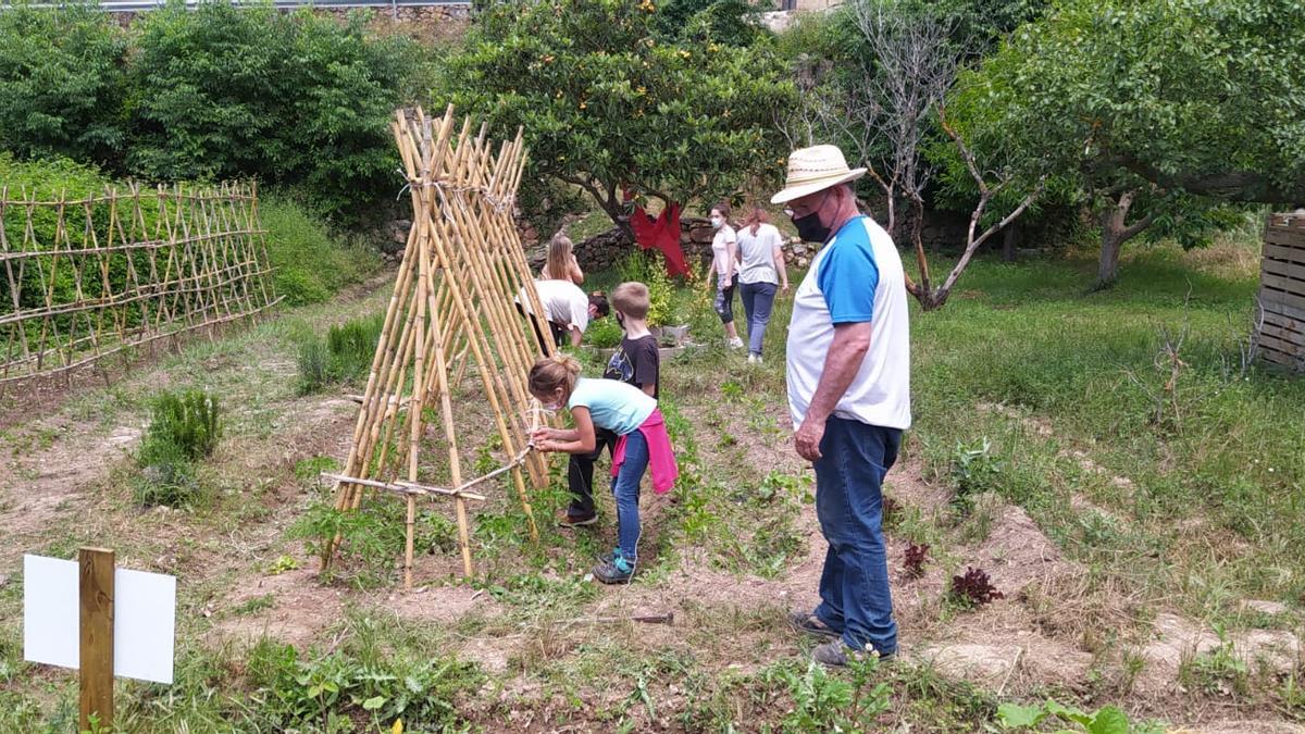 Estudiantes y vecinos del pueblo mantienen un huerto orgánico juntos para promover el patrimonio natural.