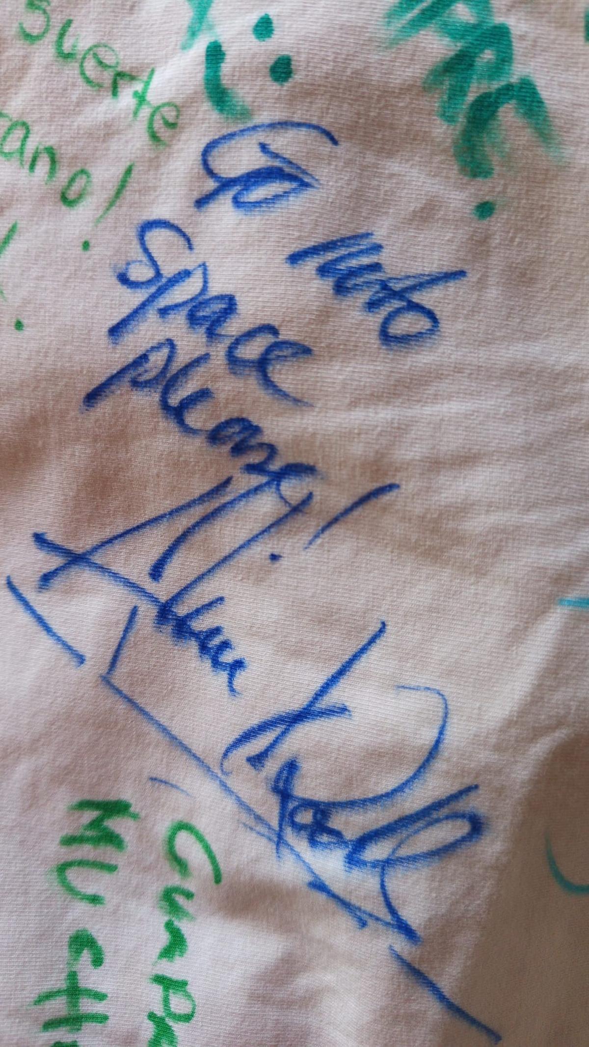 La camiseta firmada donde puede leerse "Go into space, please!" que en Español significa "¡Ve al espacio porfavor!"