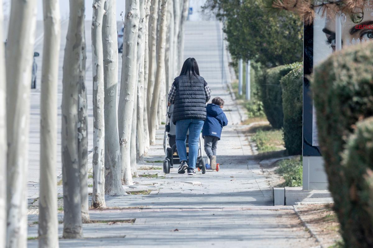 Imagen de archivo de una mujer junto a un niño en la calle.
