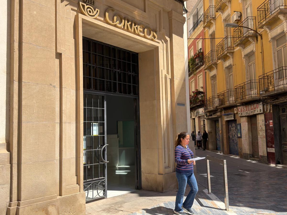 Una mujer saliendo de la Oficina de Correos de la Plaza San Francisco de Cartagena, este jueves.