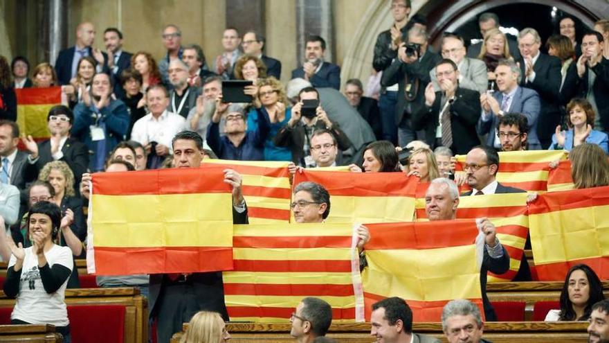 Los diputados del PP en el Parlament exhiben banderas españolas y &quot;senyeras&quot;, mientras los independentistas aplauden la aprobación del texto de &quot;desconexión&quot;.