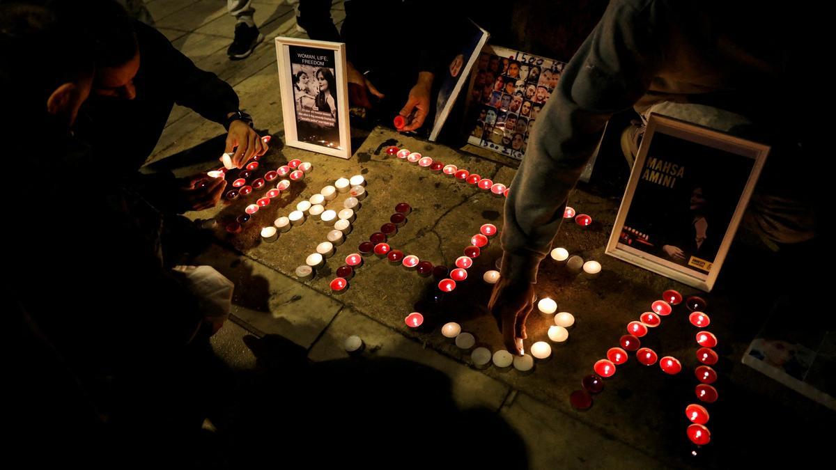 Varias personas encienden velas en un homenaje a la joven iraní Masha Amini.