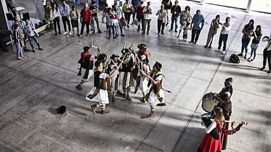 Exhibición de paloteo en el vestíbulo de Ifeza. A la derecha, visitantes de uno de los expositores.