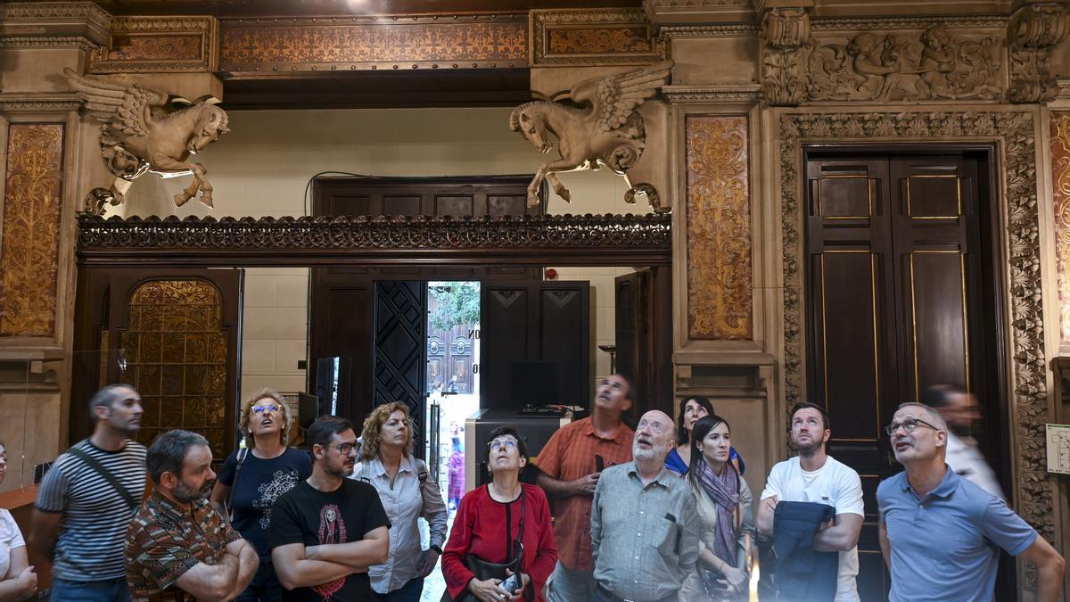 Visitantes observando la espectacular claraboya de vidrio mosacio del Palau Montaner.