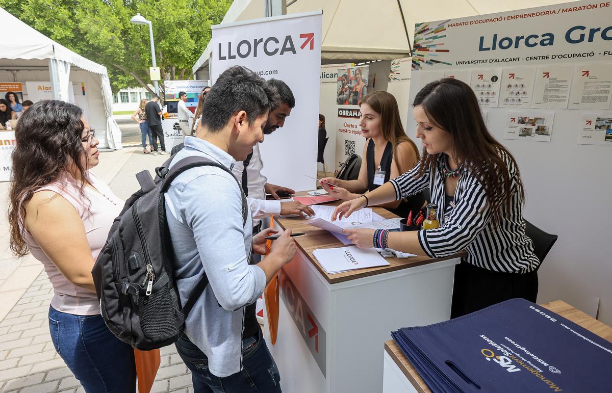 Una empresa explica a dos jóvenes las oportunidades laborales que ofrece su empresa.