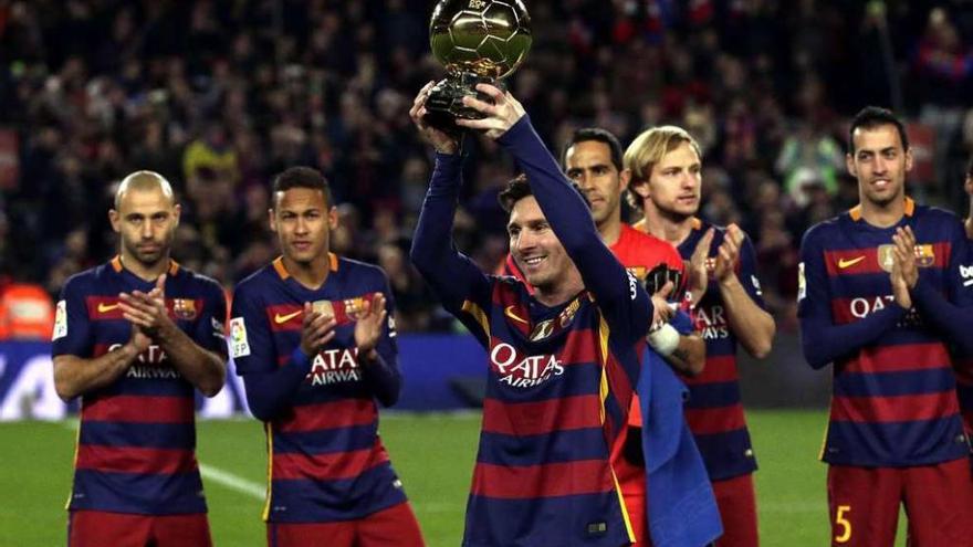 Messi, arropado por sus compañeros, ofrece el Balón de Oro al Camp Nou.