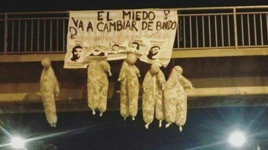 Los cinco muñecos y el cartel, en la avenida del Cid.