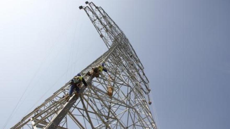 Dos tècnics de Red Eléctrica en una de les torres de la MAT