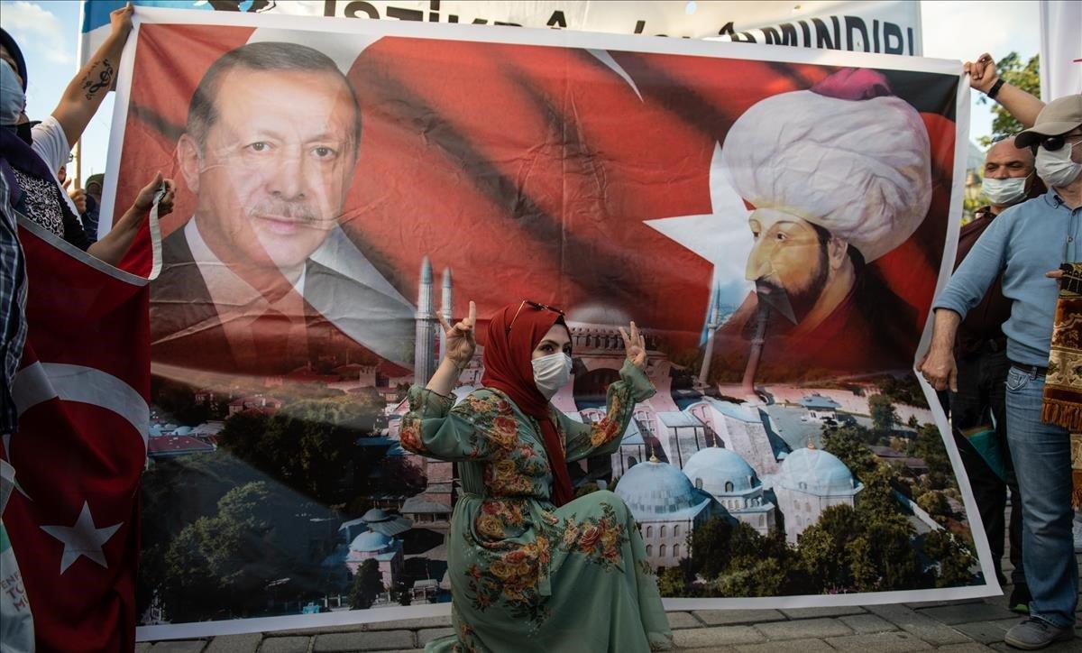 Una mujer posa ante un cartel con la representación del presidente turco, Recep Tayyip Erdogan, y del sultán otomano Mehmet II, ayer en Estambul.