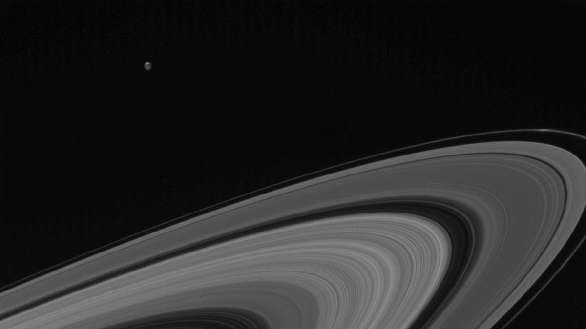 Los anillos helados de Saturno, con la pequeña luna Tethys al fondo, fotografiados por la sonda Cassini de la NASA el 13 de mayo de 2017