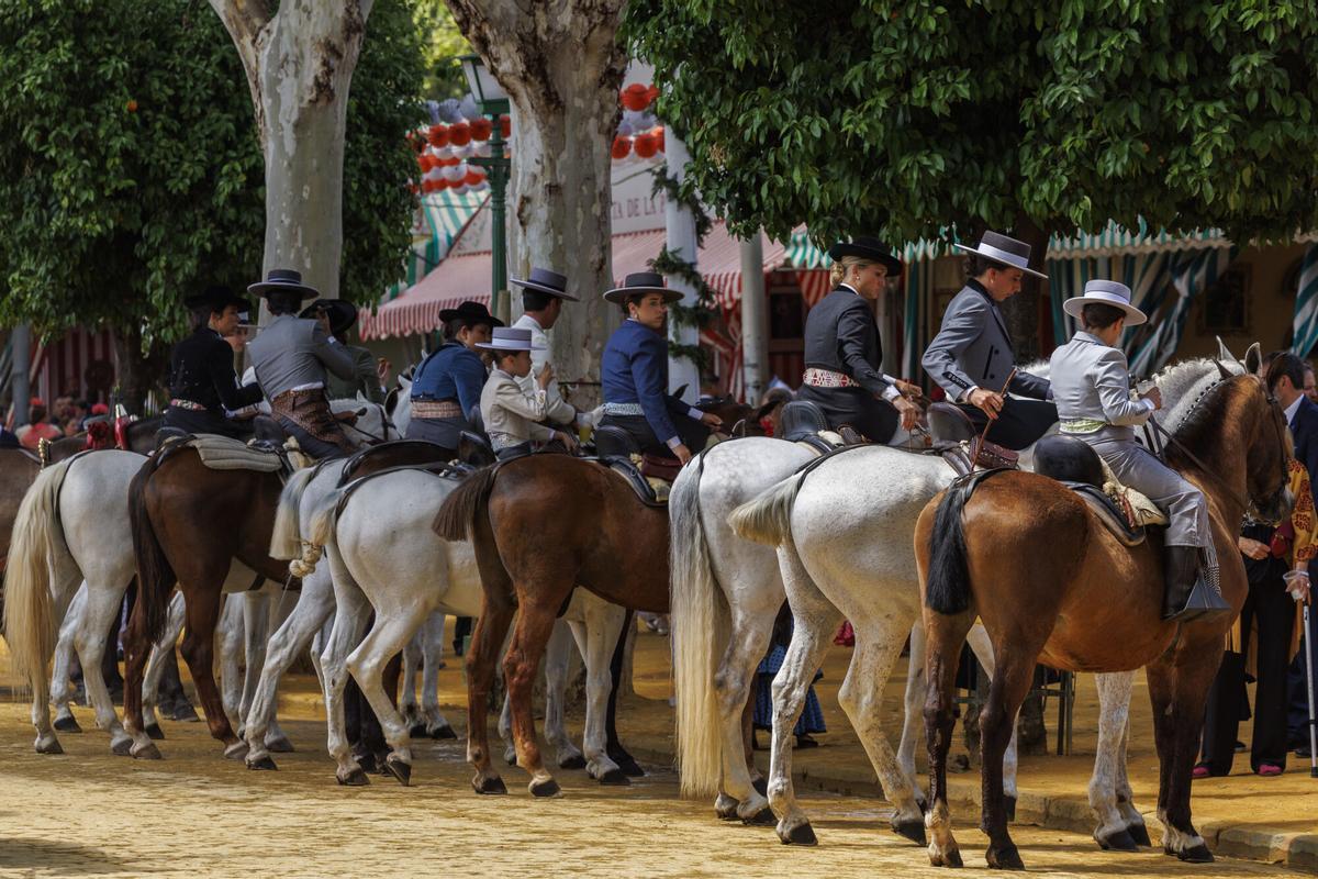Caballistas hacen un alto a la sombra durante el paseo de caballos con temperaturas primaverales.