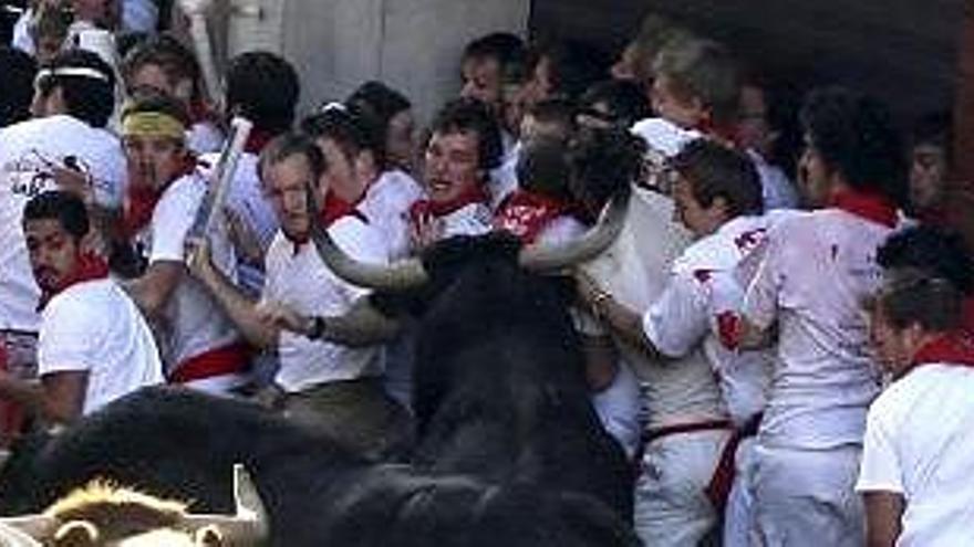 Un grupo de mozos pasa apuros en el tramo del Ayuntamiento durante el primer encierro de los Sanfermines 2008.