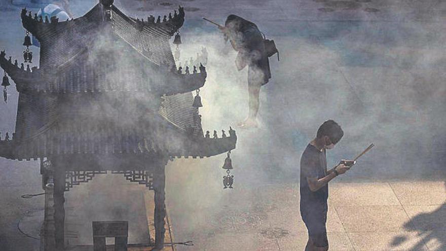 Dos personas rezan en un templo de Shanghai.