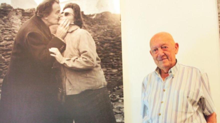 Joan Vehí davant d&#039;una reproducció molt gran d&#039;una foto feta per ell mateix l&#039;any 1961 que mostra Dalí i Gala fent-se un petó a Cadaqués