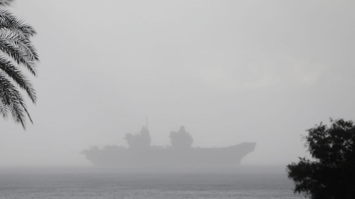 El portaaviones británico 'Queen Elizabeth' tras una cortina de lluvia tras fondear en Palma