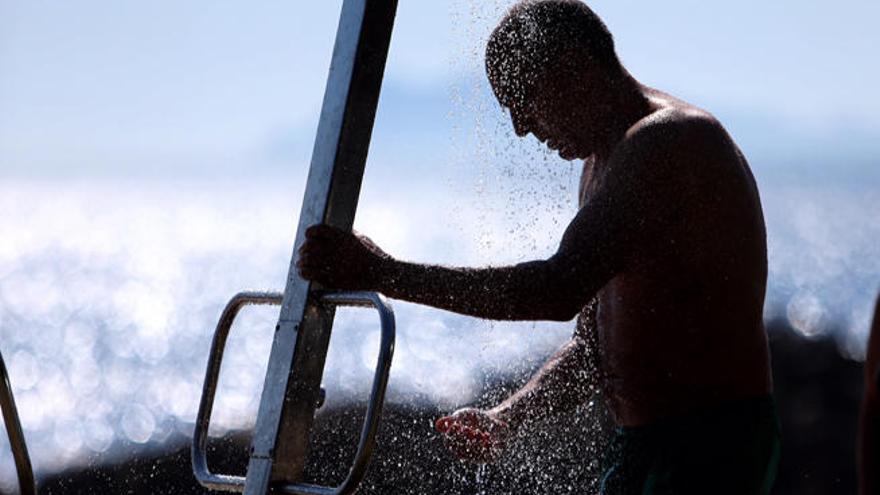 Un bañista se refresca en la playa de Samil // NICK